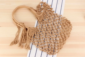 Detail of handmade macrame weaving texture and elegant cotton rope tassels on the beach bag