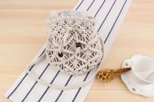 Close-up of macrame woven bucket bag featuring detailed geometric patterns and wooden beads