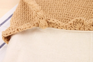 Macro detail of hand-woven cotton rope shoulder bag with wavy edges and inner lining
