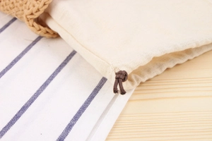 Detail of cotton drawstring inner lining and cord closure for woven beach shoulder bag