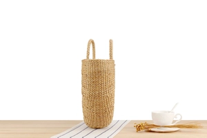 Detailed texture of handcrafted woven straw handbag on light wooden surface