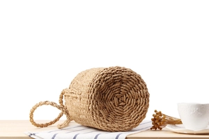 Detailed view of handmade paper straw woven bucket bag bottom with spiral weave pattern
