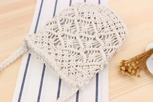 Detail of handmade macrame weave pattern on a vintage style cream cotton crossbody bag