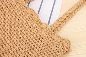 Close-up of hand-woven cotton rope shoulder bag with shell-edge detail and braided handle