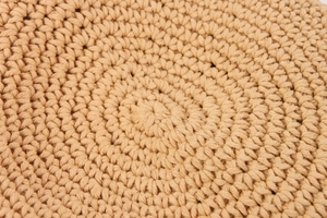 Macro shot of hand-woven cotton rope texture showing detailed crochet patterns on bag