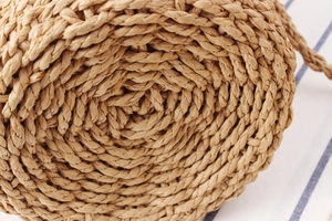 Detailed macro view of spiral woven paper rope texture on a round bucket beach bag