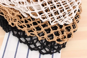 Close-up of handmade cotton rope mesh bags in white, khaki and black colors