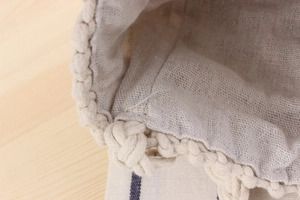 Detailed macro of handmade cotton weave and soft linen lining on a boho crossbody bag