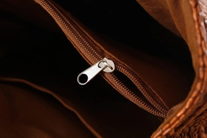 Dettaglio interno della borsa intrecciata con tasca a zip argentata e fodera in tessuto