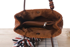 Dettaglio dell'interno della borsa in paglia intrecciata con fodera e tasca con cerniera