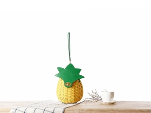 Détail du sac tressé ananas avec rabat feuille verte et fermoir doré rotatif
