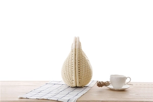 Close-up of cream woven shell handbag texture on wooden table with elegant decor