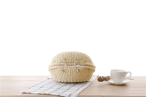 Detailed view of handmade woven shell bag with protective silver metal base studs