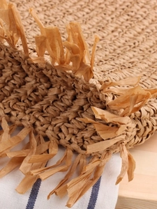 Handwoven straw tote bag with tassel trim and paper rope bohemian texture for casual look