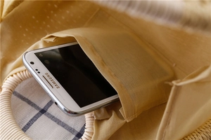 Detail of woven shell handbag interior featuring cotton lining and smartphone pocket