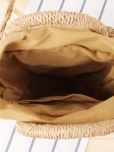 Top view of woven paper rope crossbody bag with yellow fabric lining and interior pocket