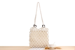 Detail of hand-woven cotton mesh beach bag with wooden rings and inner fabric lining