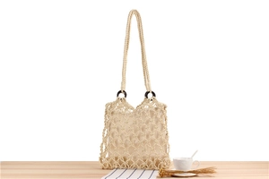 Close-up of bohemian hollow cotton rope woven bag with brown wooden rings and beige liner
