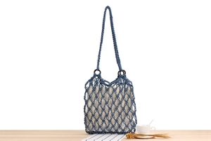 Detail of woven mesh beach bag with cotton rope, wooden ring and canvas liner