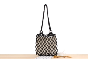 Detail of bohemian black woven mesh bag with wooden rings and canvas inner pouch