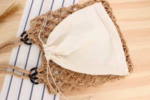 Top view of handmade woven cotton net bag with wooden handle and canvas inner pouch