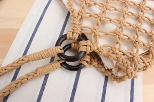 Detail of hand-woven cotton net bag with round wood ring connector and canvas lining