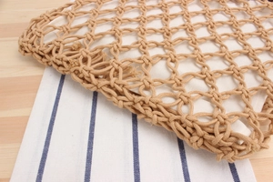 Close-up of handmade woven mesh beach bag with wooden ring handle and cotton lining