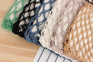 Detail of colorful hand-woven macrame bags with wooden rings and canvas liners