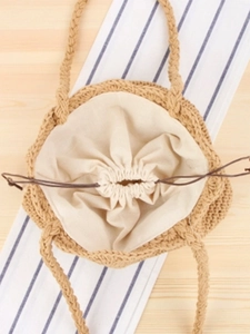 Handwoven straw bucket bag with cotton lining and drawstring closure for summer beach