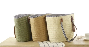 Three woven bucket bags in olive, camel, and cream with striped lining and leather handles