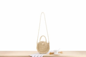 Detail showing the spiral woven texture of the beige round paper rope beach bag