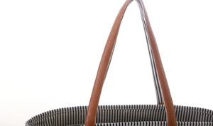 Close-up of blue white striped canvas tote bag with brown leather handles and stitching
