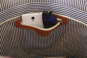 Detail of blue striped lining and interior zipper pocket with phone and sunglasses