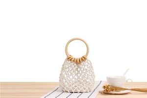 Close-up of handmade macrame mesh tote bag with natural round wooden handles and cotton rope
