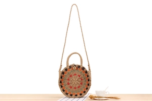 Detail view of round handmade woven bag with geometric patterns on a wooden surface