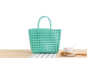 Detail of mint green woven PVC tote bag showing basket texture and round handles