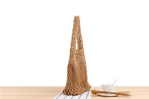 Detail of handmade crochet mesh bag in light brown showing the hollow knit pattern