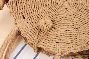 Detailed macro view of woven straw bag showing spiral paper rope texture and inner lining