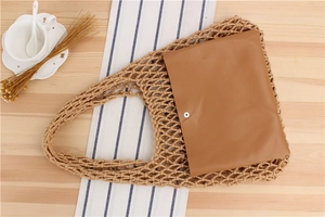 Detail of hand-woven mesh bag with a brown faux leather inner pouch and metal button