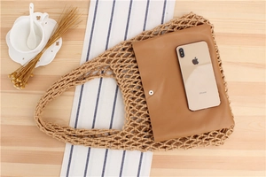 Detail of handmade macramé net bag with leather inner pouch showing storage capacity
