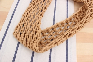 Detail of hand-woven khaki net bag handle showing intricate texture and sturdy cotton rope knots