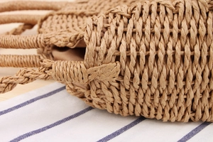 Detailed close-up of handmade woven paper straw beach bag texture and sturdy handles