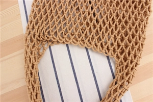 Close-up of hand-woven mesh bag in beige cotton rope with hollow knot texture detail