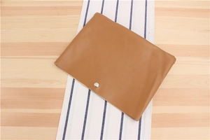 Detailed top view of a brown faux leather envelope pouch with a silver snap button