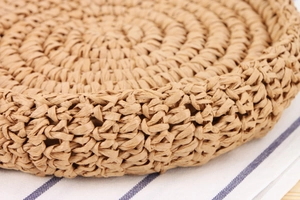 Detailed macro view of the natural hand-woven straw texture on a round beach bag