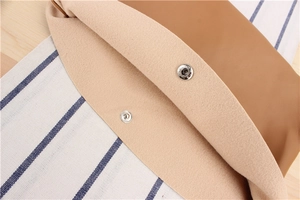 Detail of brown leather bag with silver magnetic snap button and beige suede interior