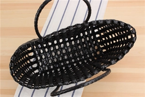 Close-up of black PVC woven tote bag showing intricate hollow cross-weave patterns