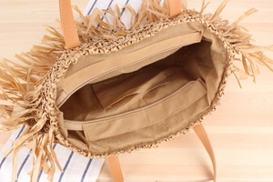 Close-up of woven straw tote bag interior showing beige lining and secure zipper pocket