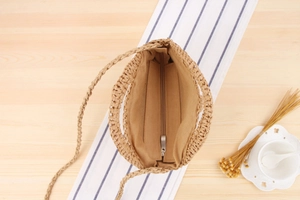 Detailed top view of handmade woven straw shoulder bag featuring a zipper closure and lining