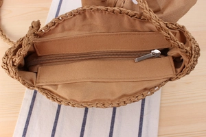 Detail of handmade woven straw bag with secure zipper closure and fabric lining